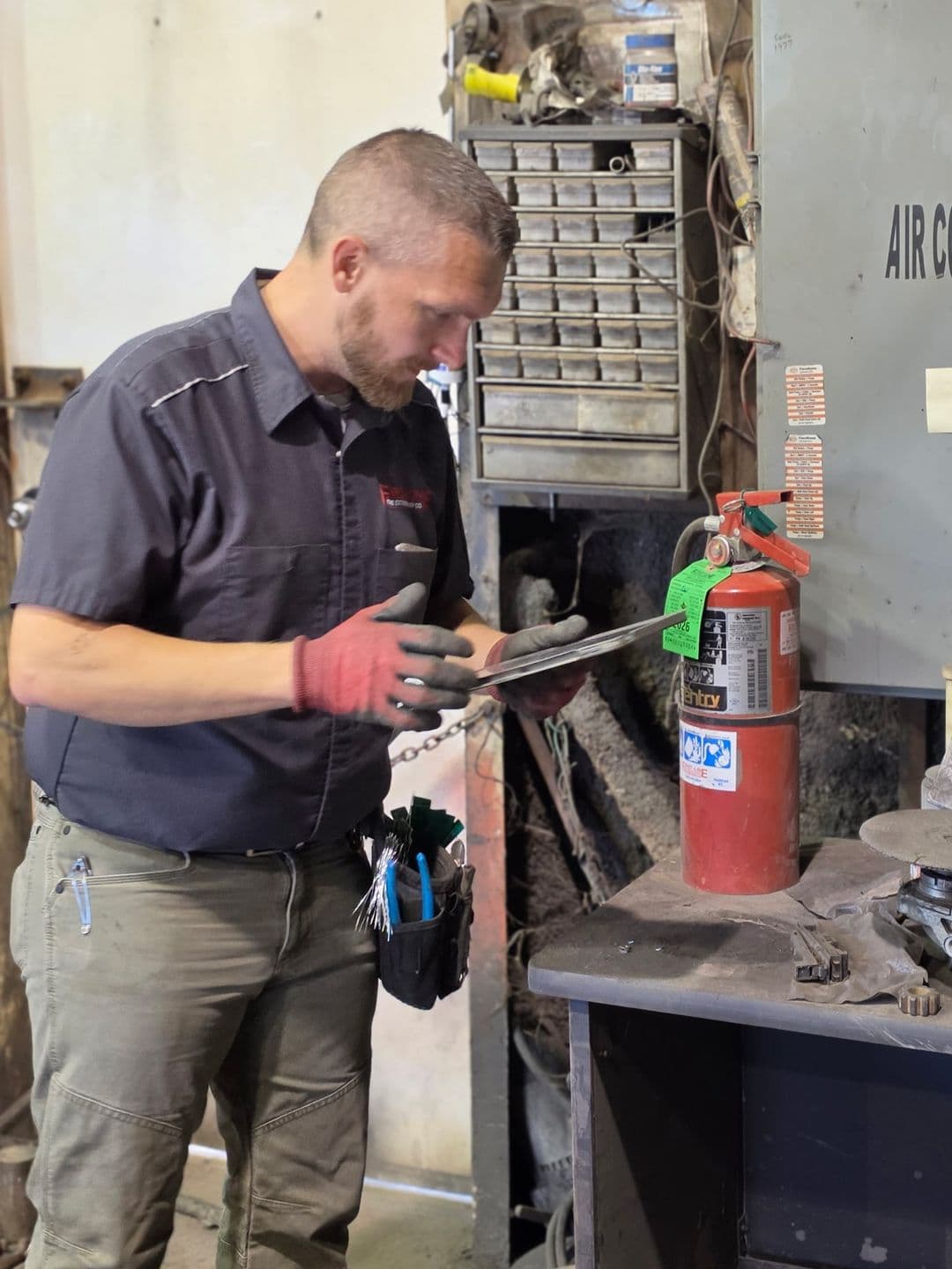 First-Line technician recording a fire extinguisher inspection on a tablet