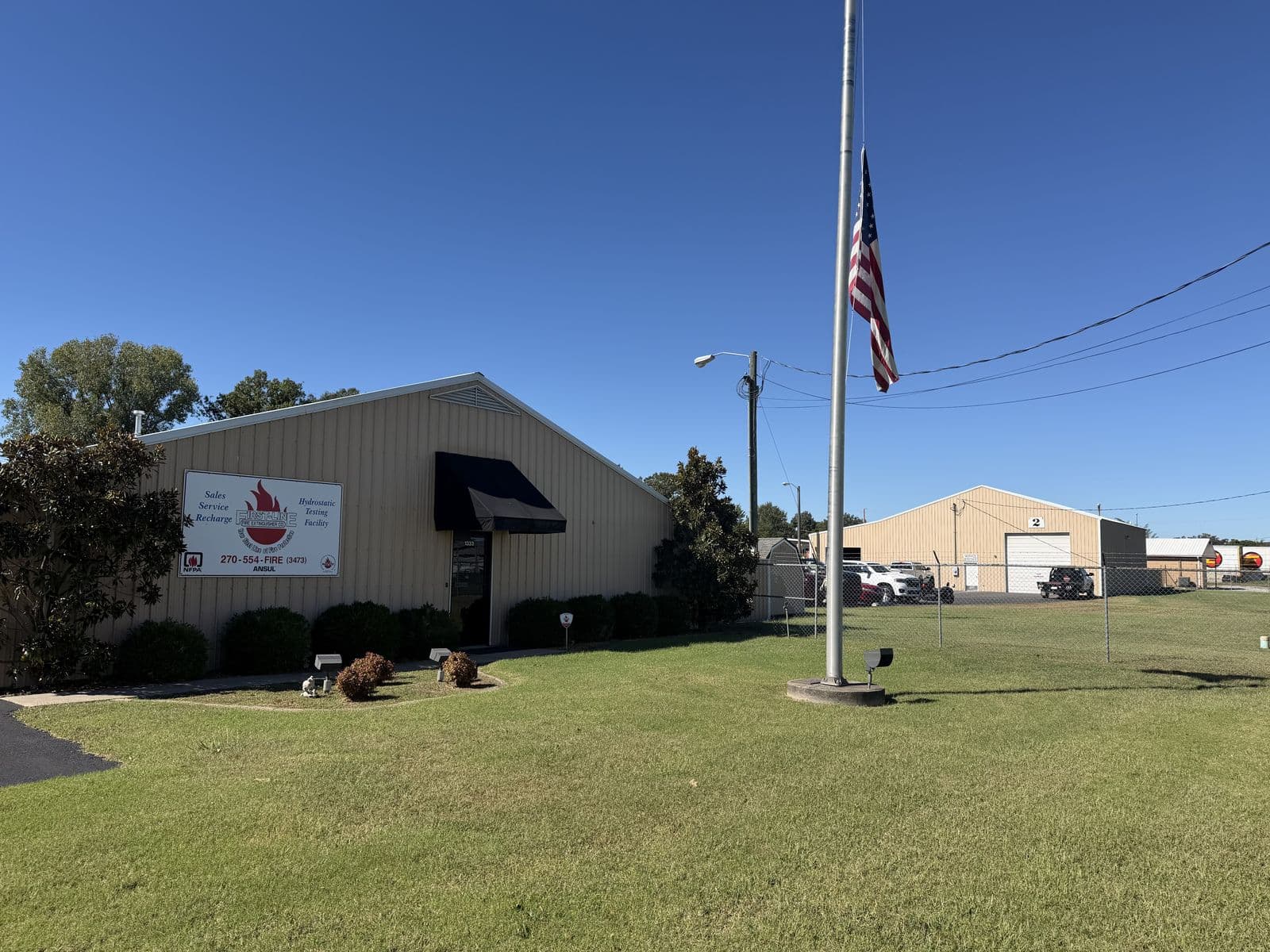 First-Line Fire Extinguisher Co. shop in Paducah, Kentucky, with the company sign and an American flag out front