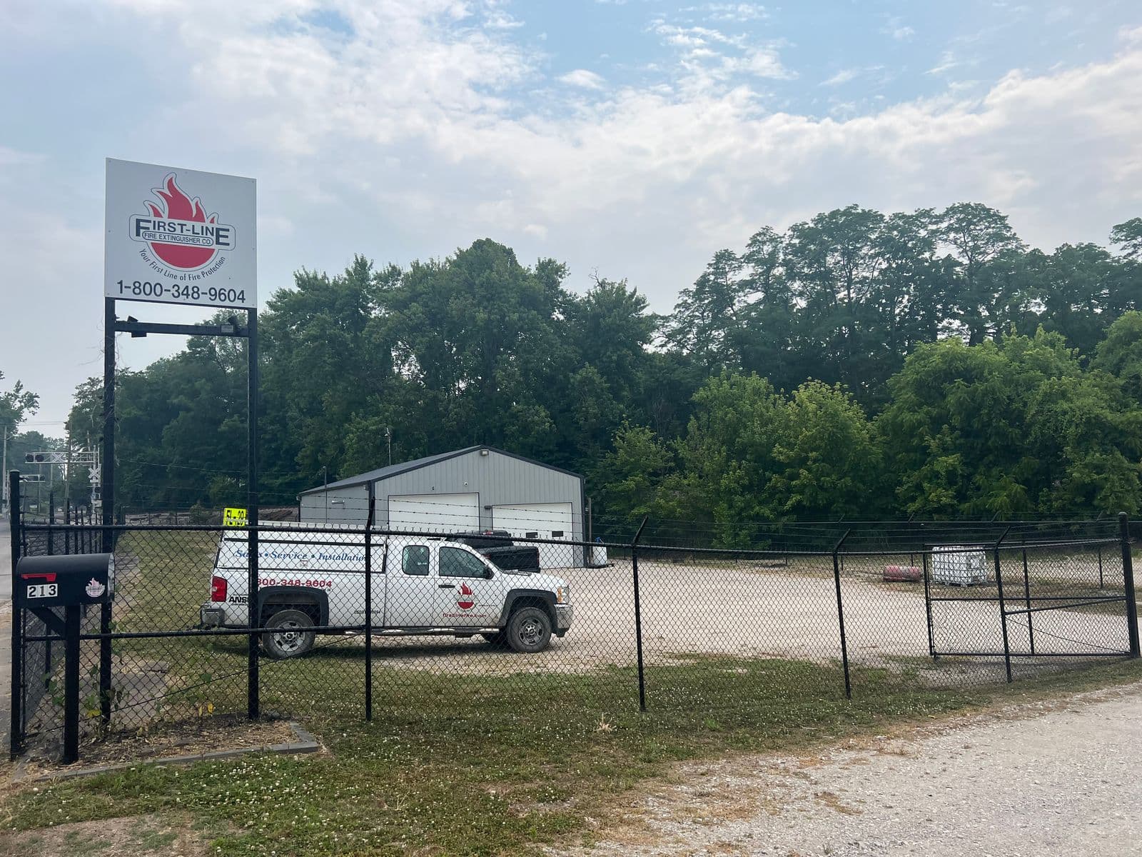 First-Line Fire Extinguisher Co. shop in Princeton, Indiana, with the company sign out front and a white First-Line pickup in the fenced lot